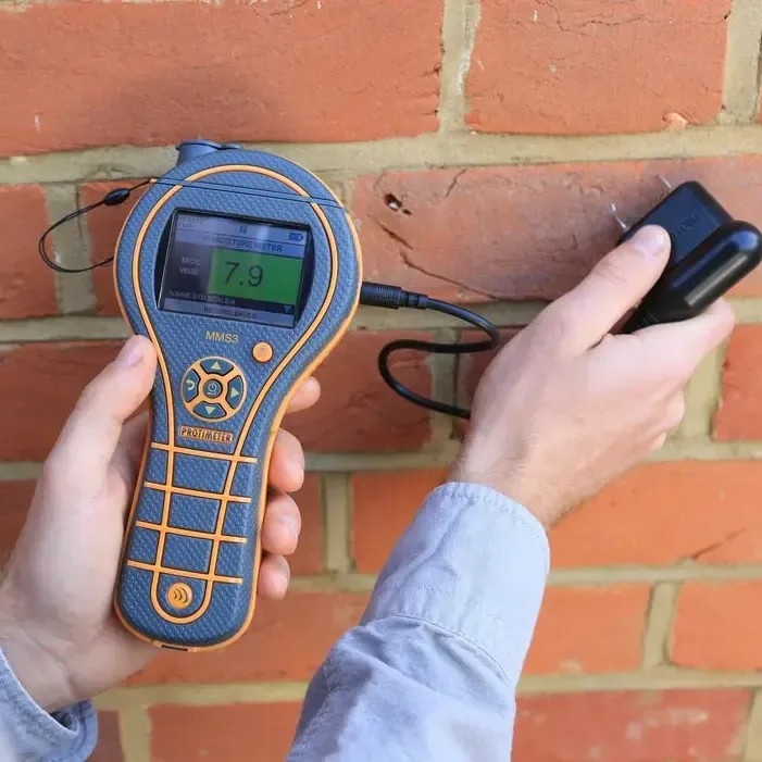 Moisture meter checking a brick wall for water after a leak