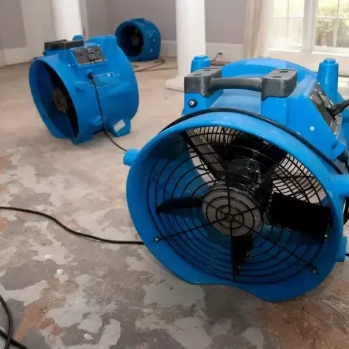 Blue air movers drying an exposed subfloor