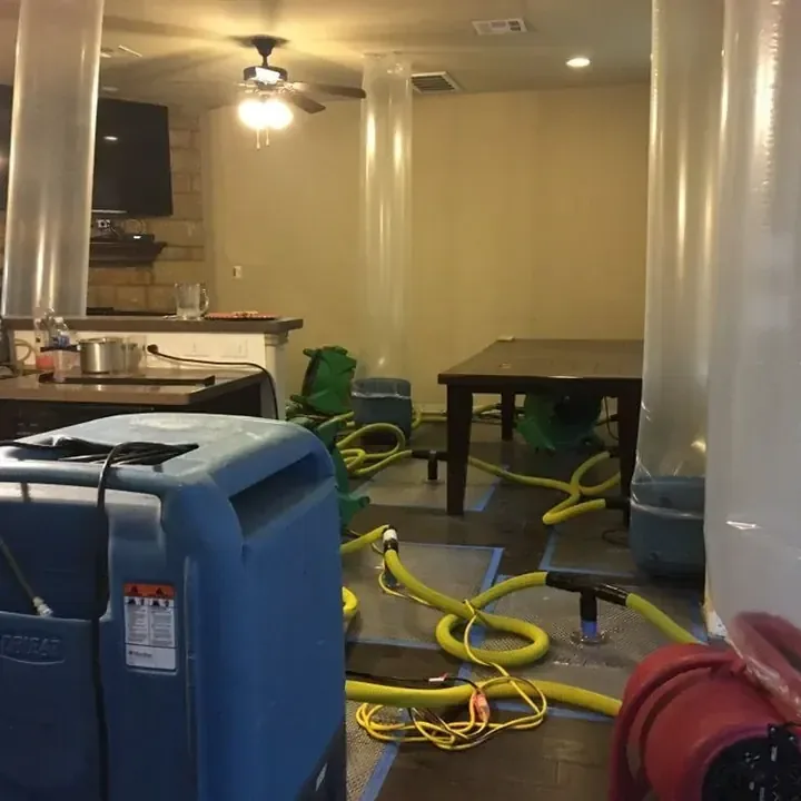 Drying equipment and yellow hoses arranged around a dining table beside a kitchen