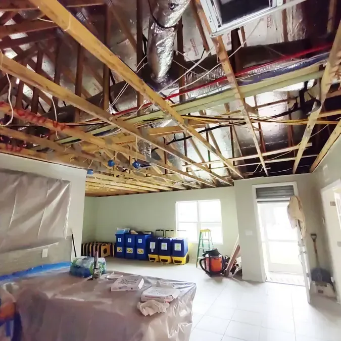 Opened ceiling exposing framing above a room with drying equipment