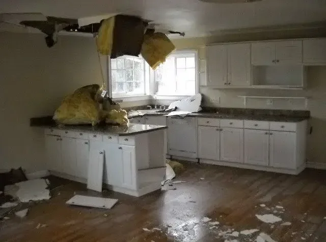 Collapsed kitchen ceiling with wet insulation and debris below