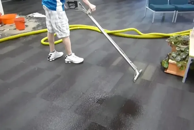 Extraction wand removing water from a carpeted floor